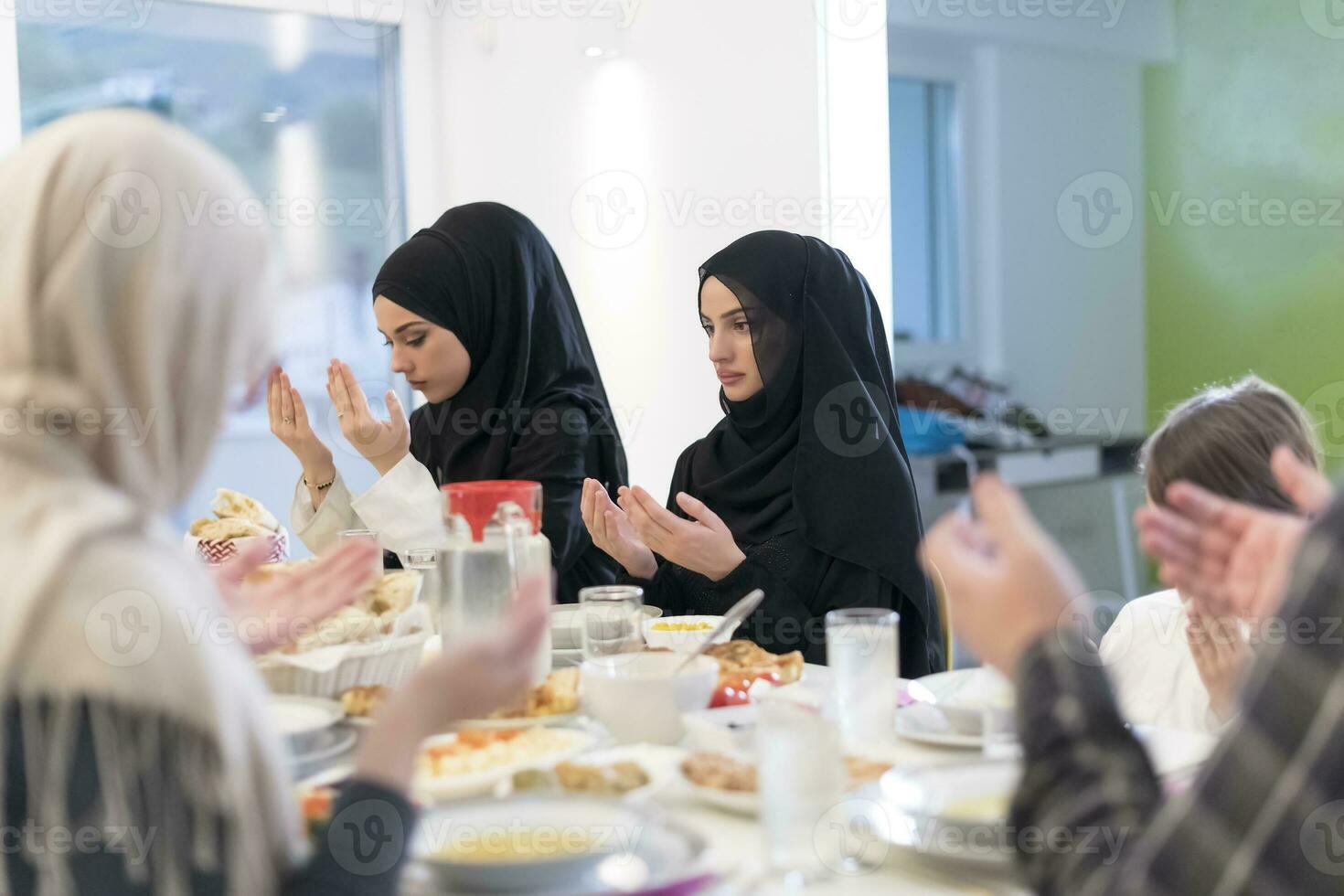 Muslim family making iftar dua to break fasting during Ramadan. photo