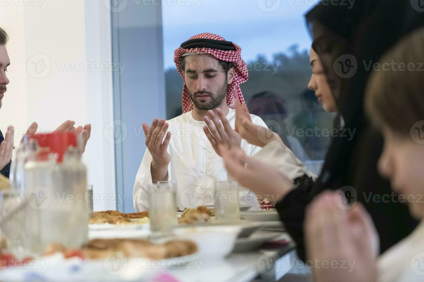 Muslim family making iftar dua to break fasting during Ramadan. photo