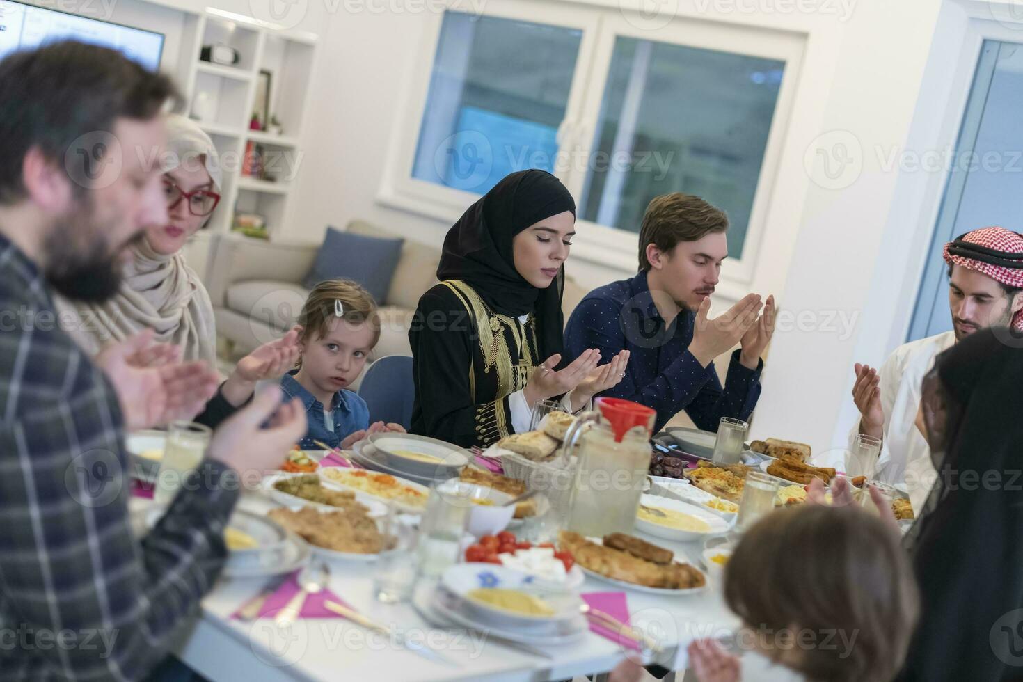 Muslim family making iftar dua to break fasting during Ramadan. photo