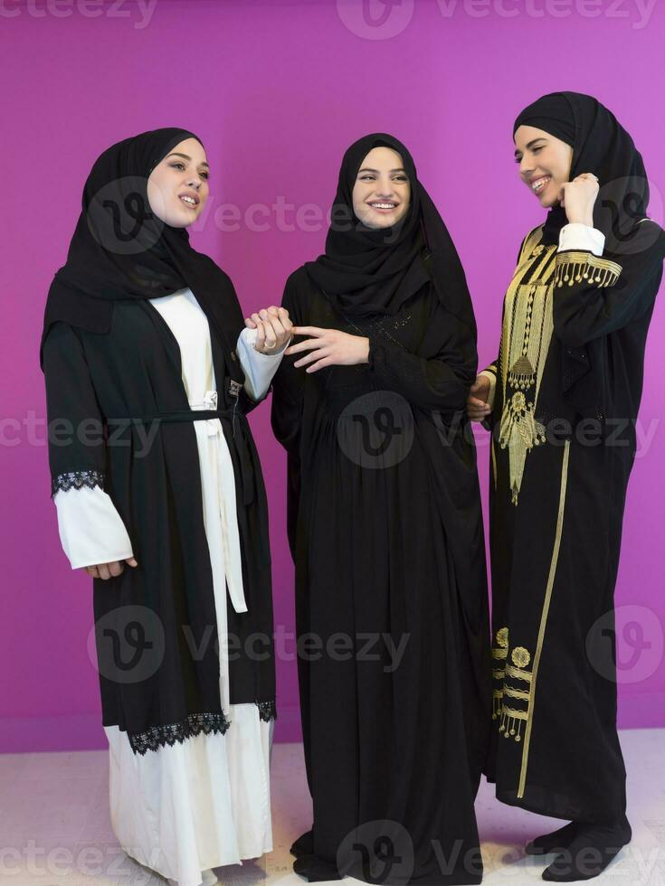 beautiful muslim woman in fashinable dress with hijab isolated on modern plastic pink background in studio representing concept of modern islam and ramadan kareem photo