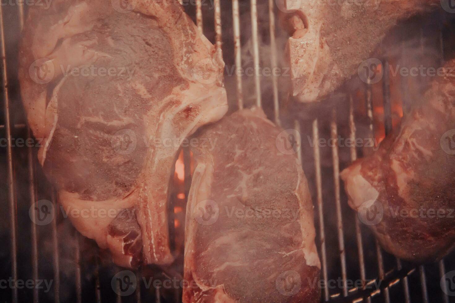 Close-up photo of delicious meat being grilled. In the background, friends and family are sitting and waiting for a meal