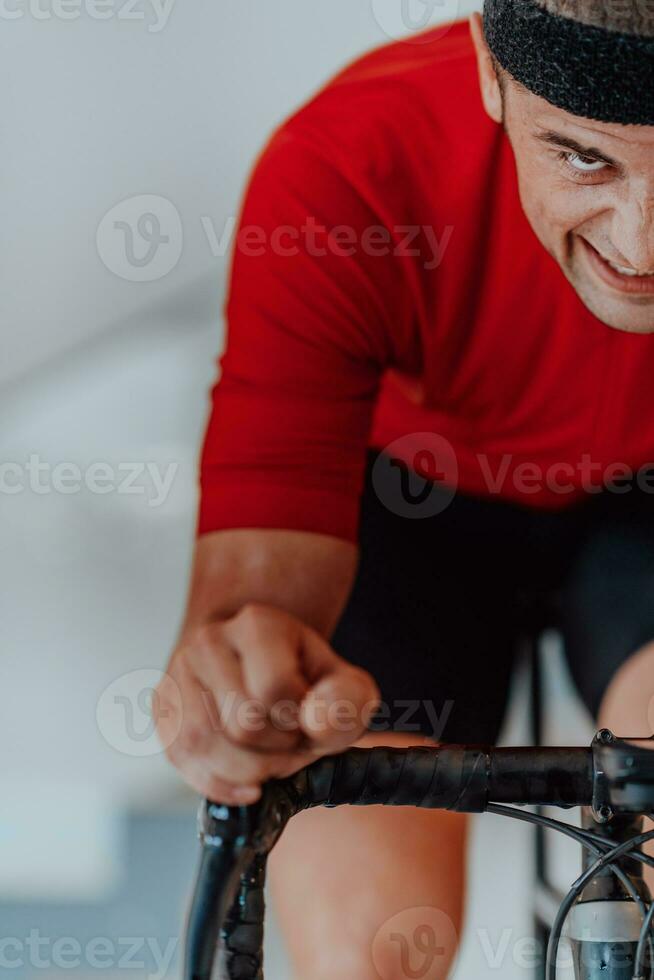 A man riding a triathlon bike on a machine simulation in a modern living room. Training during pandemic conditions. photo