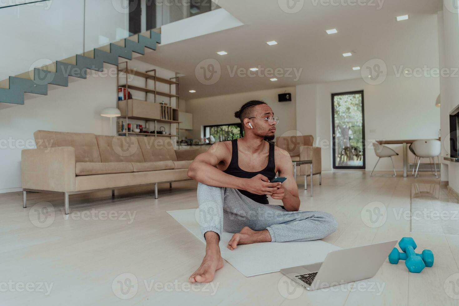 Training At Home. Sporty man doing training while watching online tutorial on laptop, exercising in living room, free space. photo