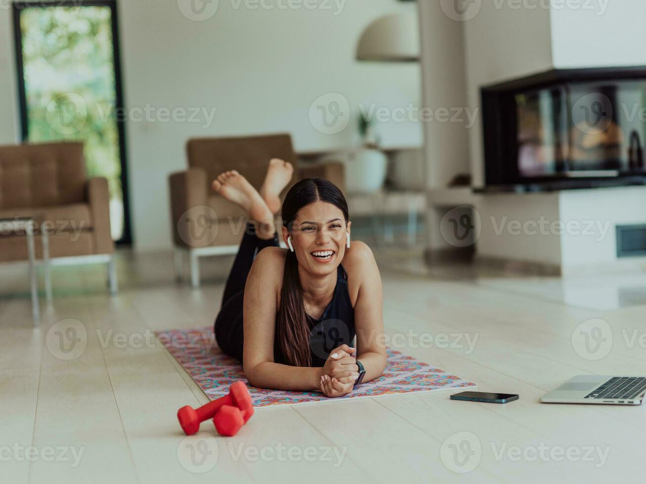 joven mujer descansando después en línea formación mientras acostado en el vivo habitación piso foto