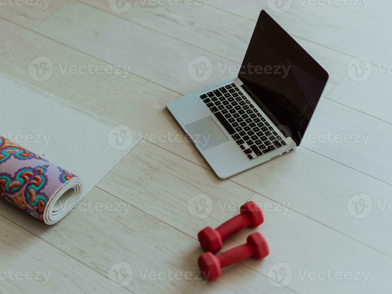 foto de un computadora portátil, pesas y auriculares en el piso de el vivo habitación. en línea formación concepto