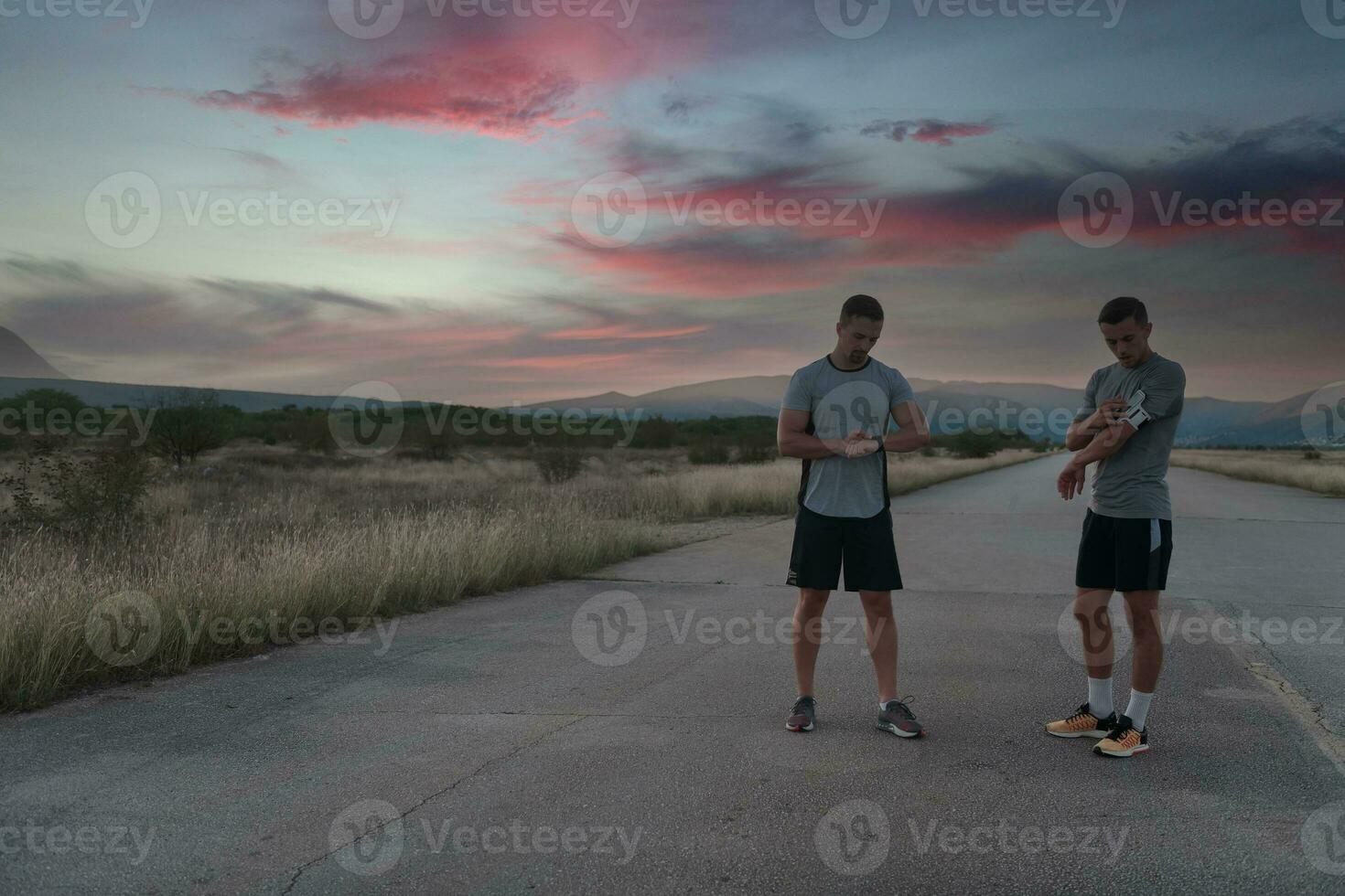 deporte Pareja mirando a un reloj inteligente mientras en pie en el país la carretera. descansando después trotar y corriendo ejercicio y comprobación corazón Velocidad y legumbres. foto