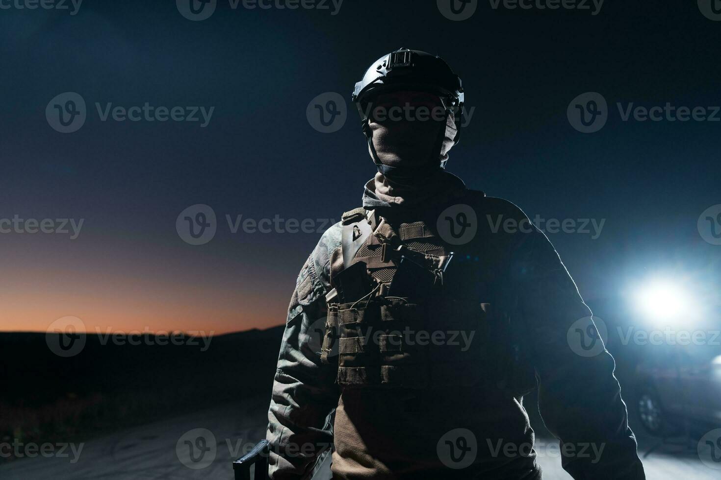 Ejército soldado en combate uniformes con un asalto rifle, plato portador y combate casco yendo en un peligroso misión en un lluvioso noche. foto