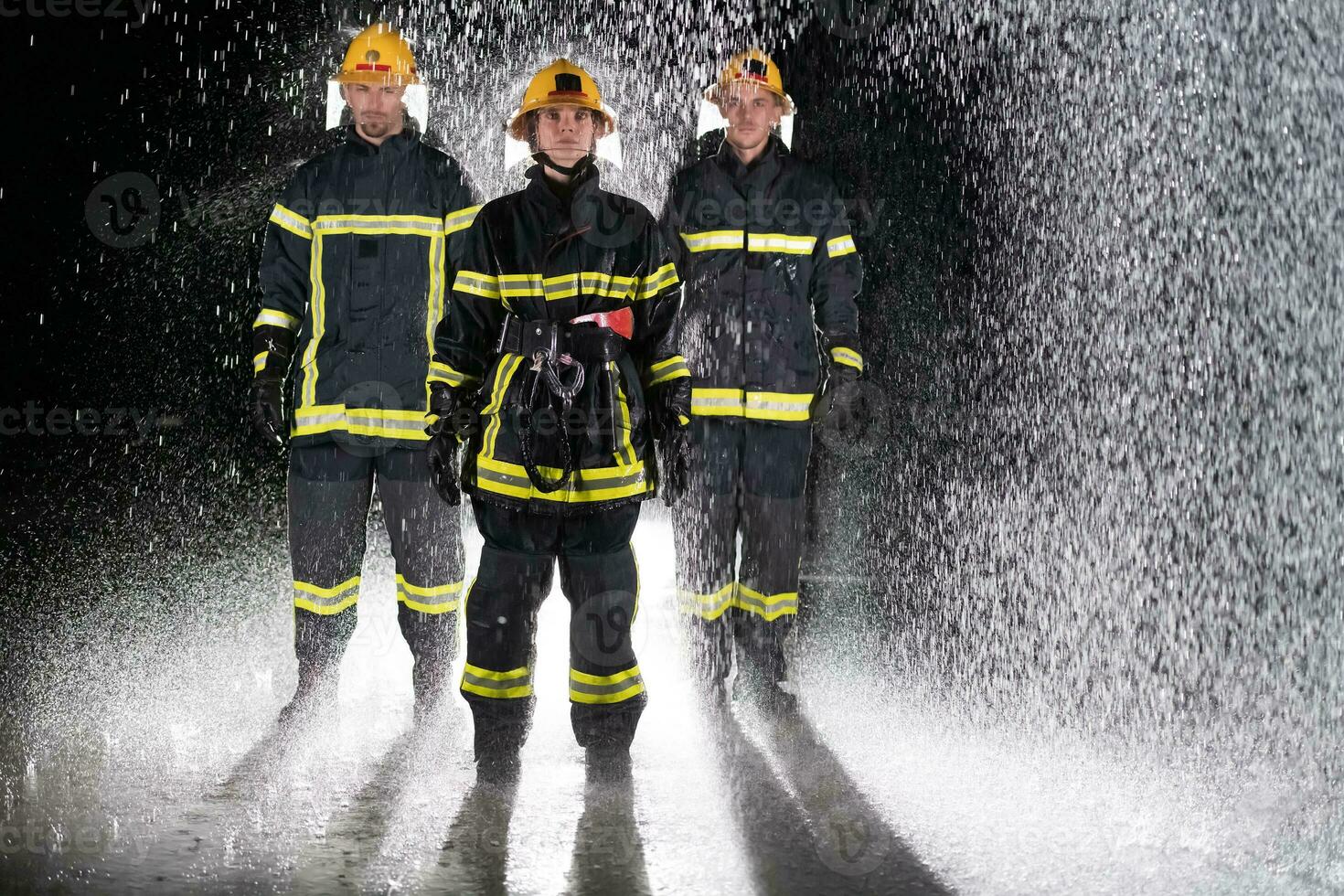 Portrait of a group of firefighters standing and walking brave and optimistic with a female as team leader. photo