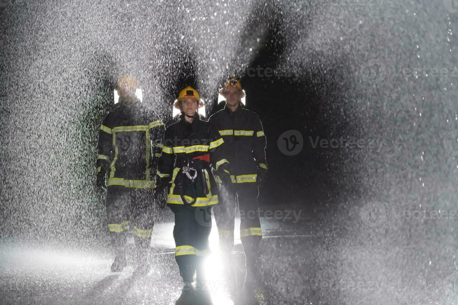 retrato de un grupo de bomberos en pie y caminando valiente y optimista con un hembra como equipo líder. foto