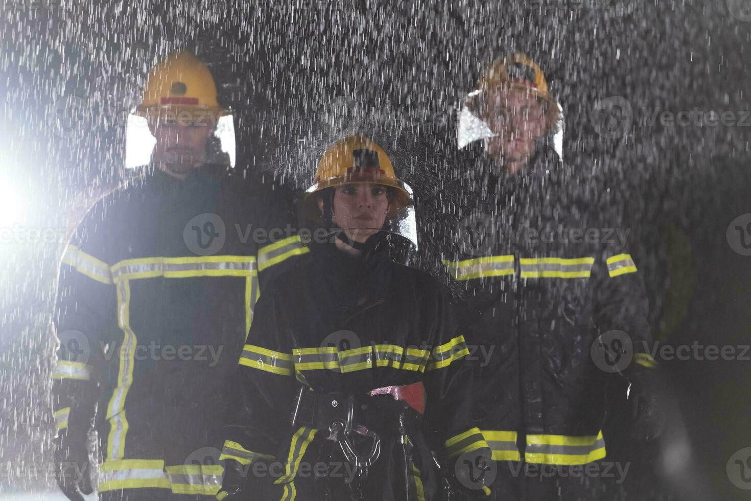 Portrait of a group of firefighters standing and walking brave and optimistic with a female as team leader. photo