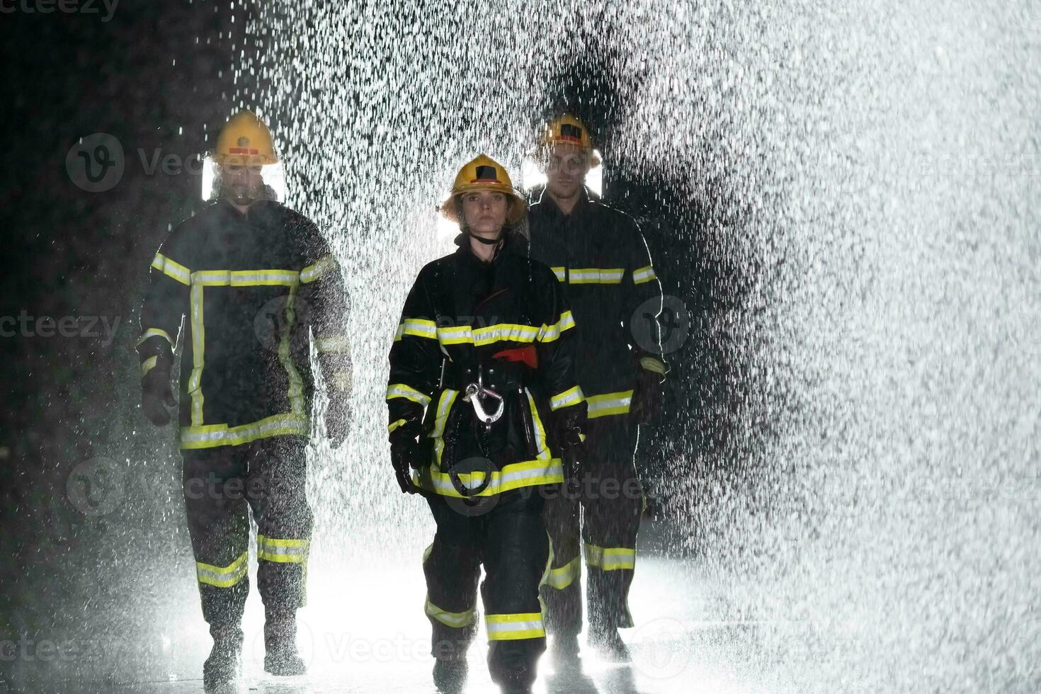Portrait of a group of firefighters standing and walking brave and optimistic with a female as team leader. photo
