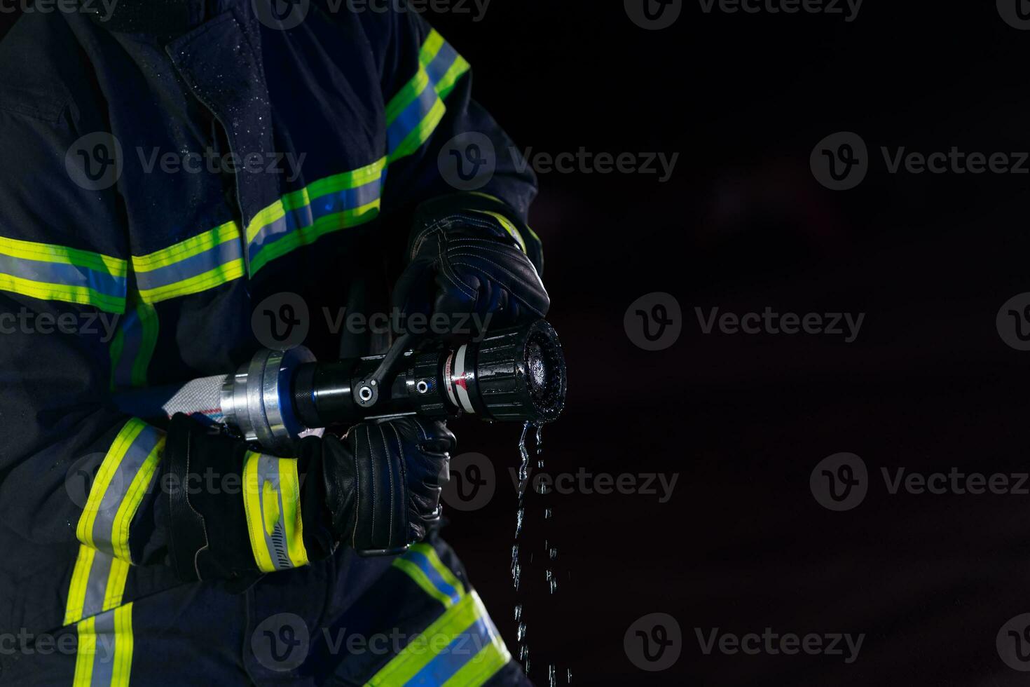 Firefighters use a water hose to eliminate a fire hazard. Team of firemen in the dangerous rescue mission. photo