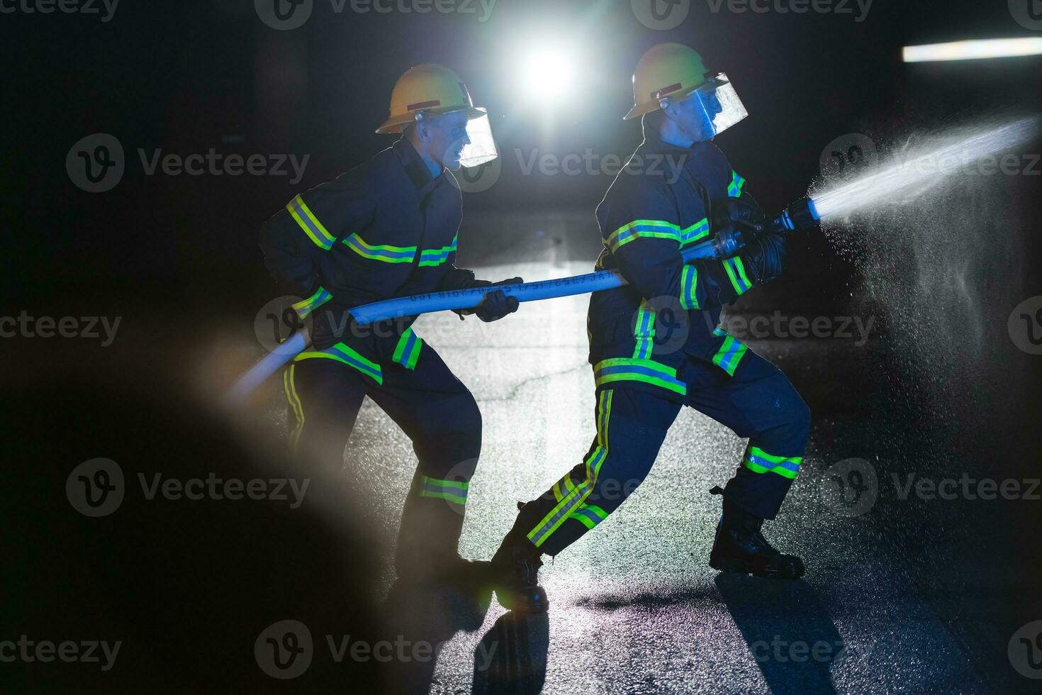 bomberos utilizar un agua manguera a eliminar un fuego peligro. equipo de bomberos en el peligroso rescate misión. foto