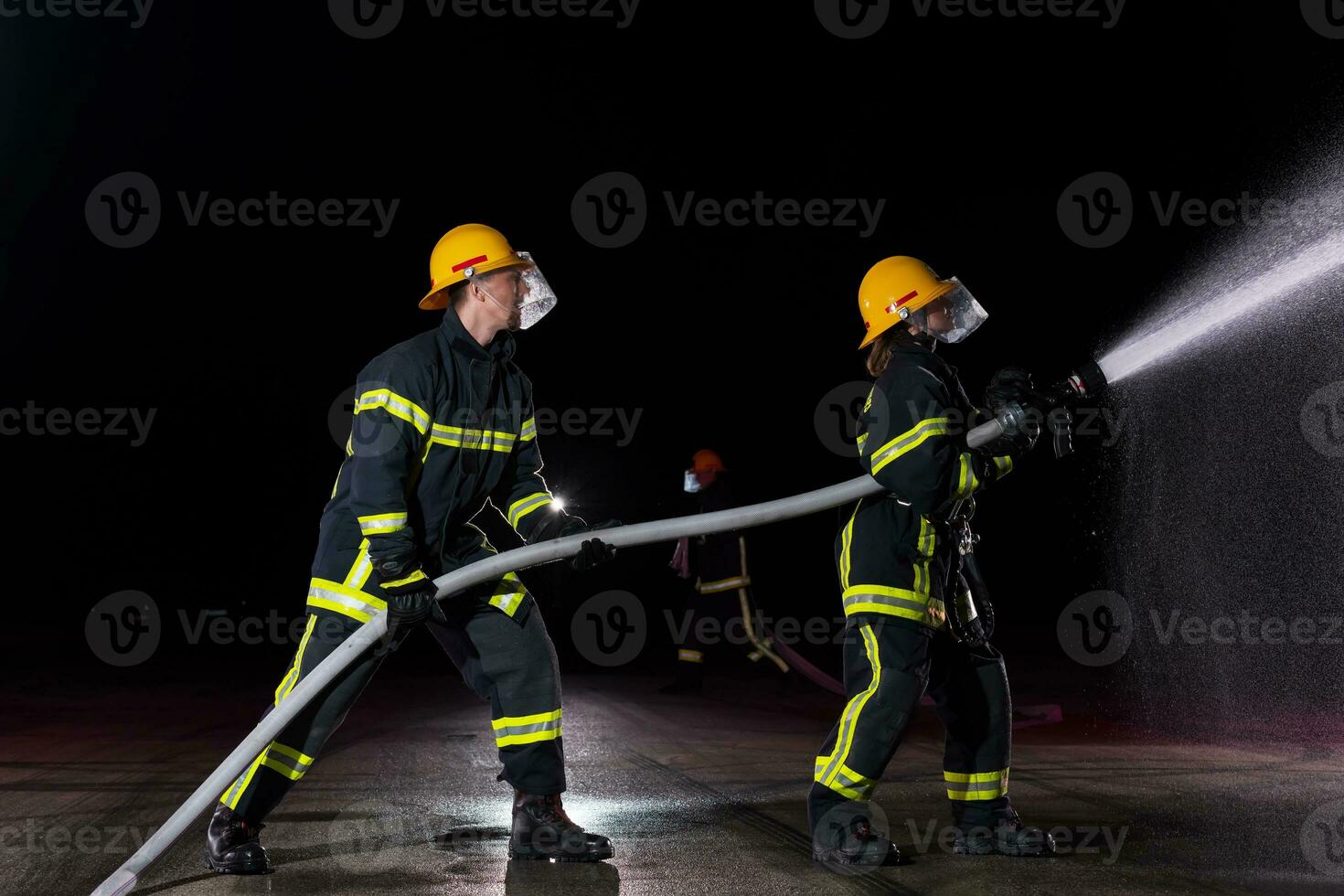 bomberos utilizando un agua manguera a eliminar un fuego peligro. equipo de hembra y masculino bomberos en peligroso rescate misión. foto