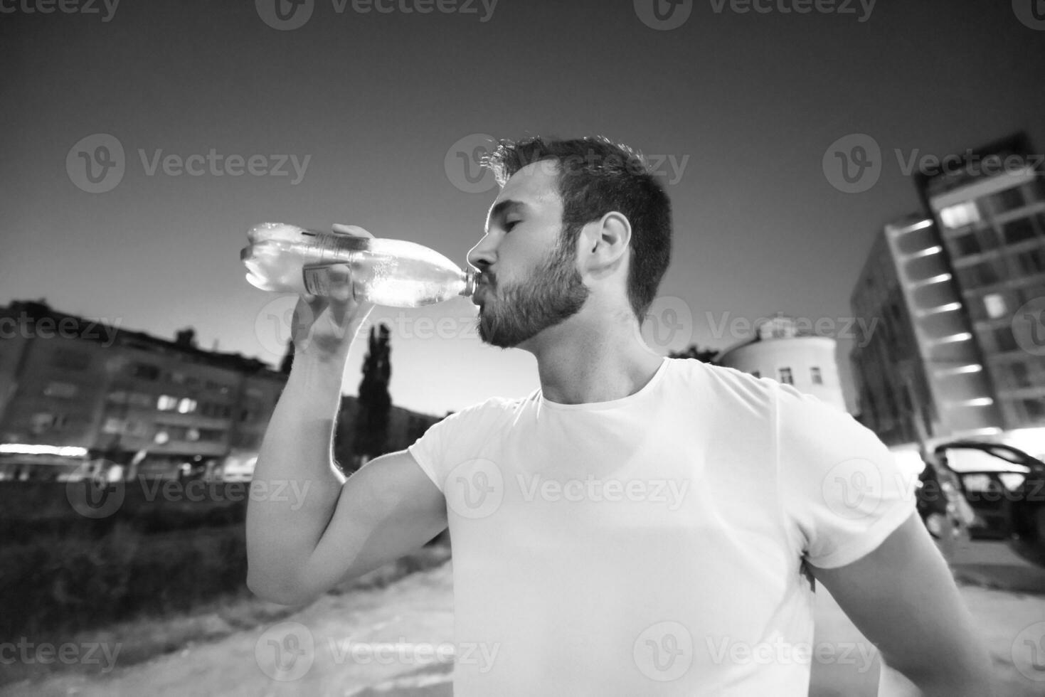 man drinking water after running session photo