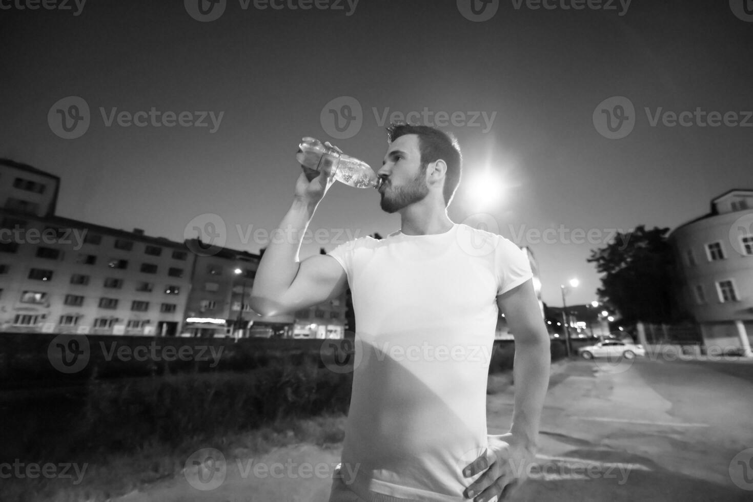 hombre bebiendo agua después de la sesión de carrera foto
