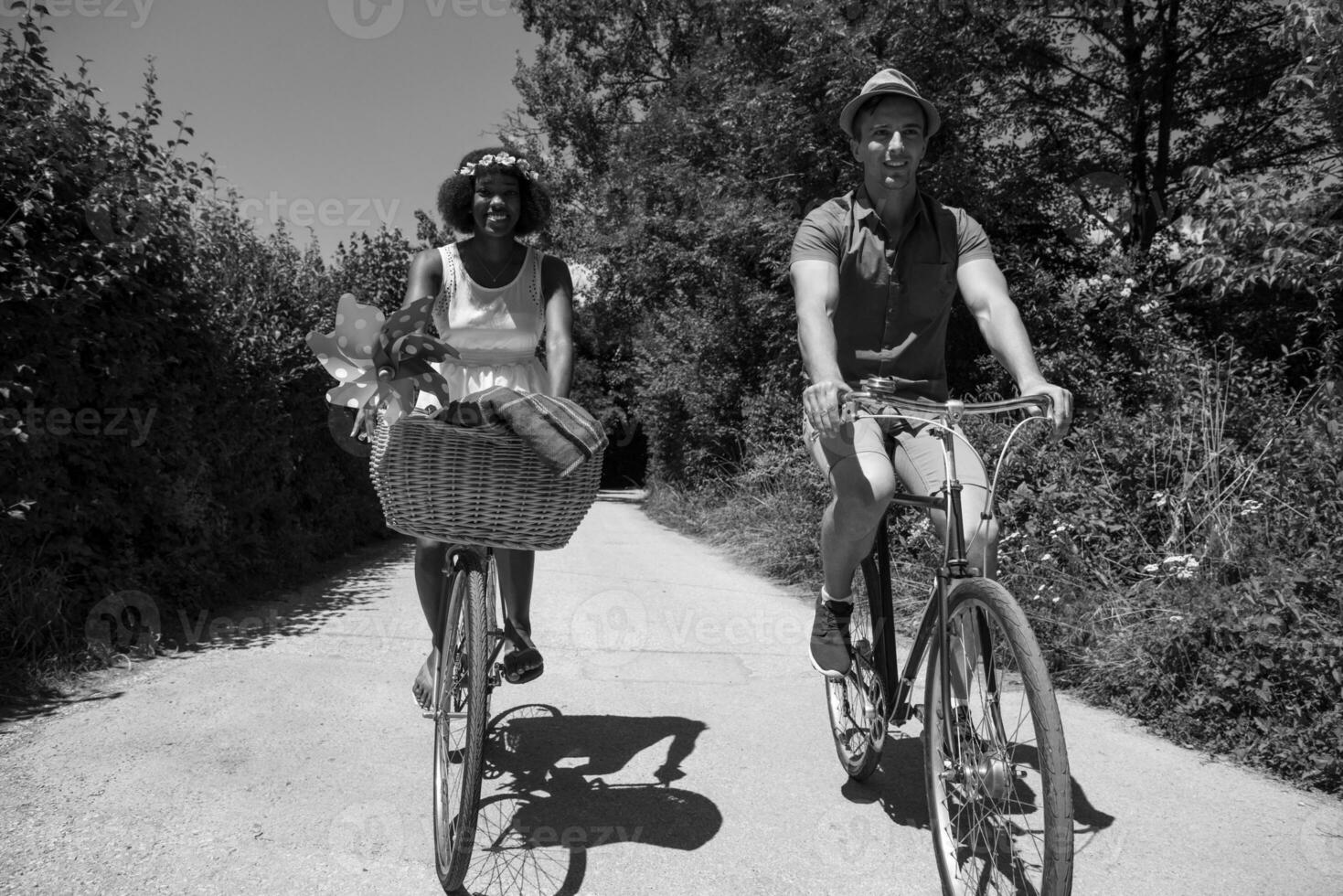 joven pareja multiétnica dando un paseo en bicicleta en la naturaleza foto