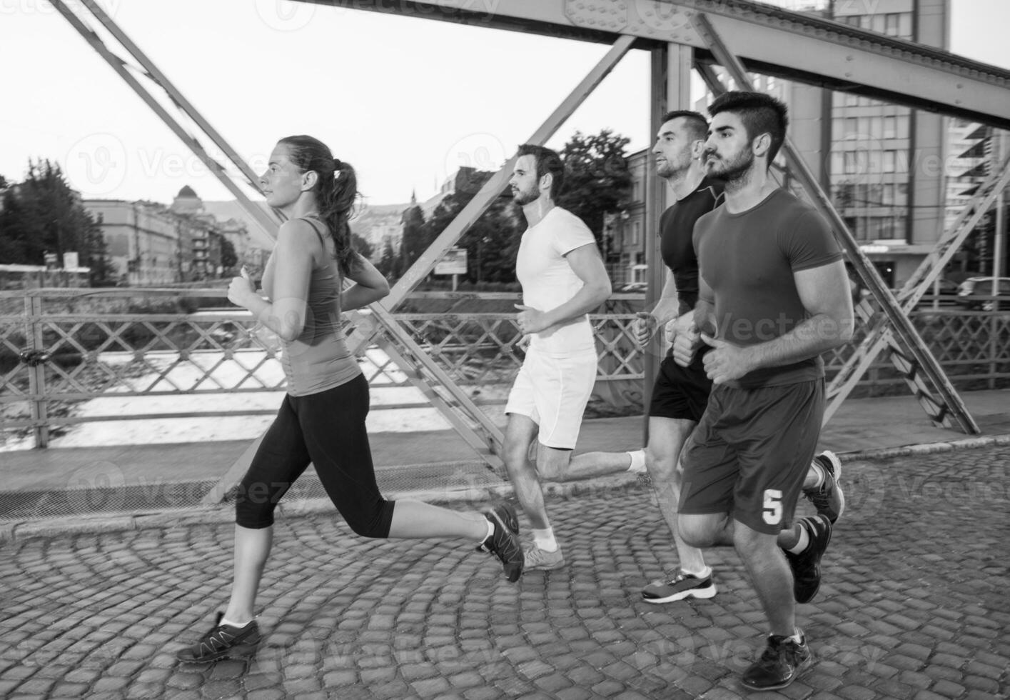 group of young people jogging across the bridge photo