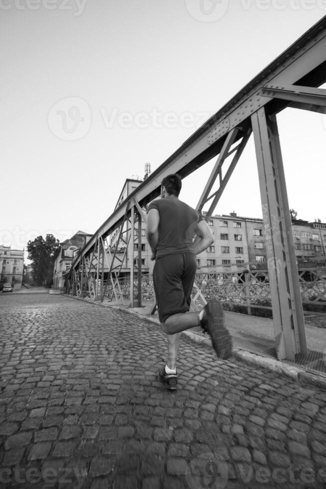 man jogging across the bridge at sunny morning photo