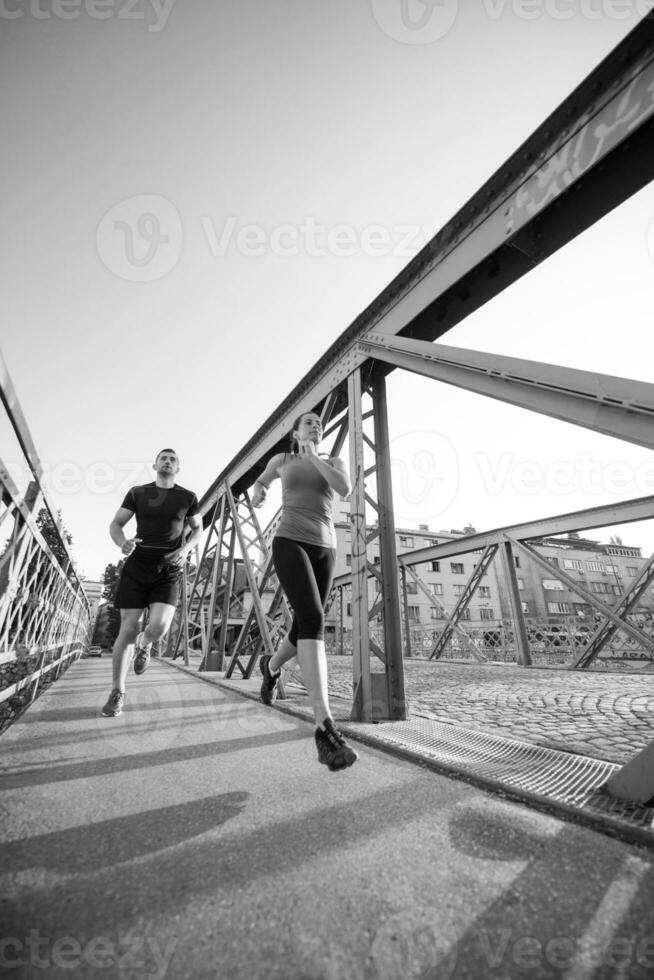 pareja joven corriendo por el puente en la ciudad foto