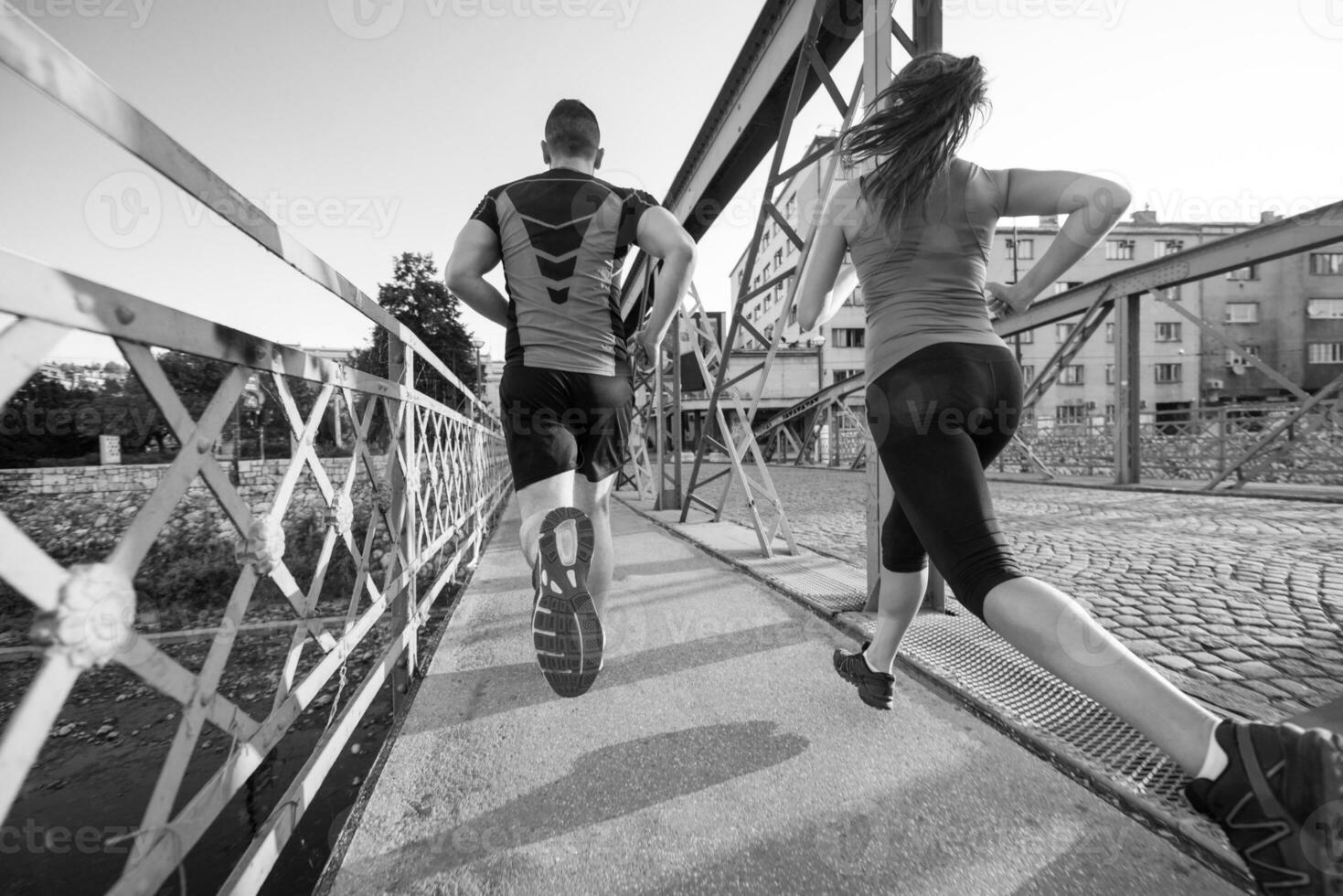 pareja joven corriendo por el puente en la ciudad foto