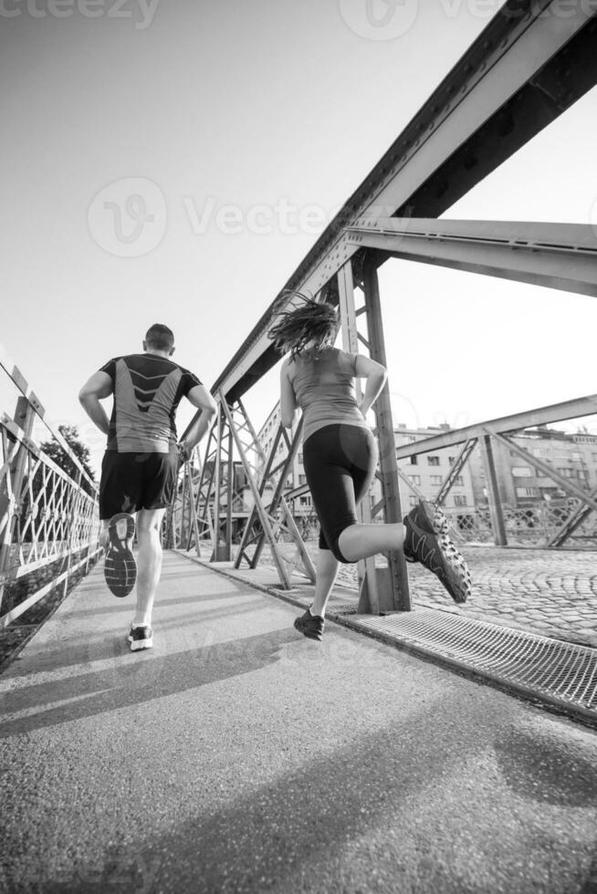 pareja joven corriendo por el puente en la ciudad foto
