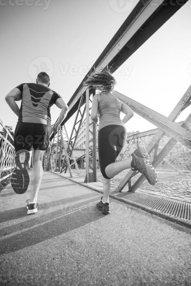 pareja joven corriendo por el puente en la ciudad foto