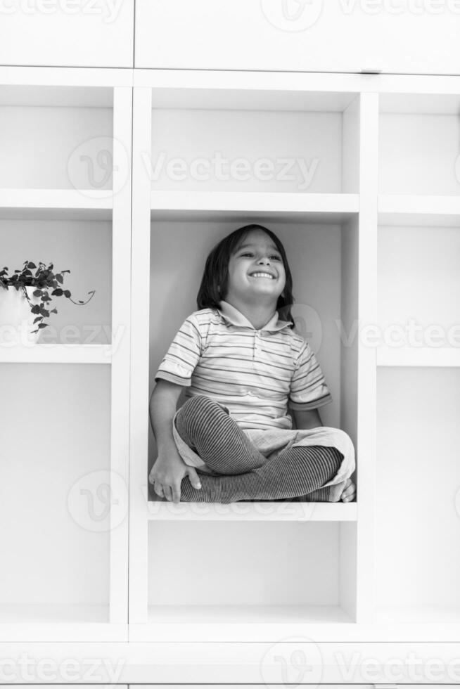 young boy posing on a shelf photo