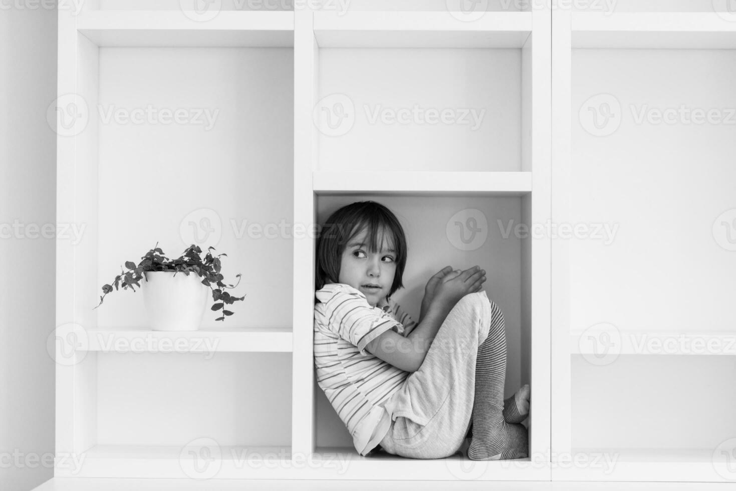 young boy posing on a shelf photo