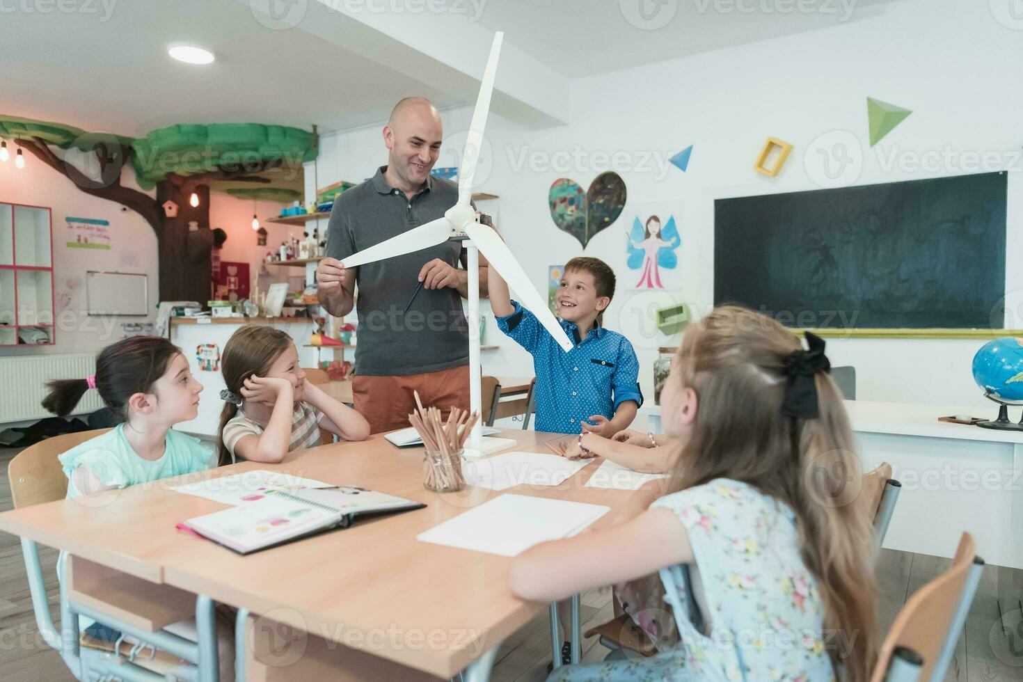 Elementary School Stem Robotics Classroom Diverse Group of Children Building and Programming windmill ecology robot concept. Together Talking and Working as a Team. Creative Robotics Engineering photo