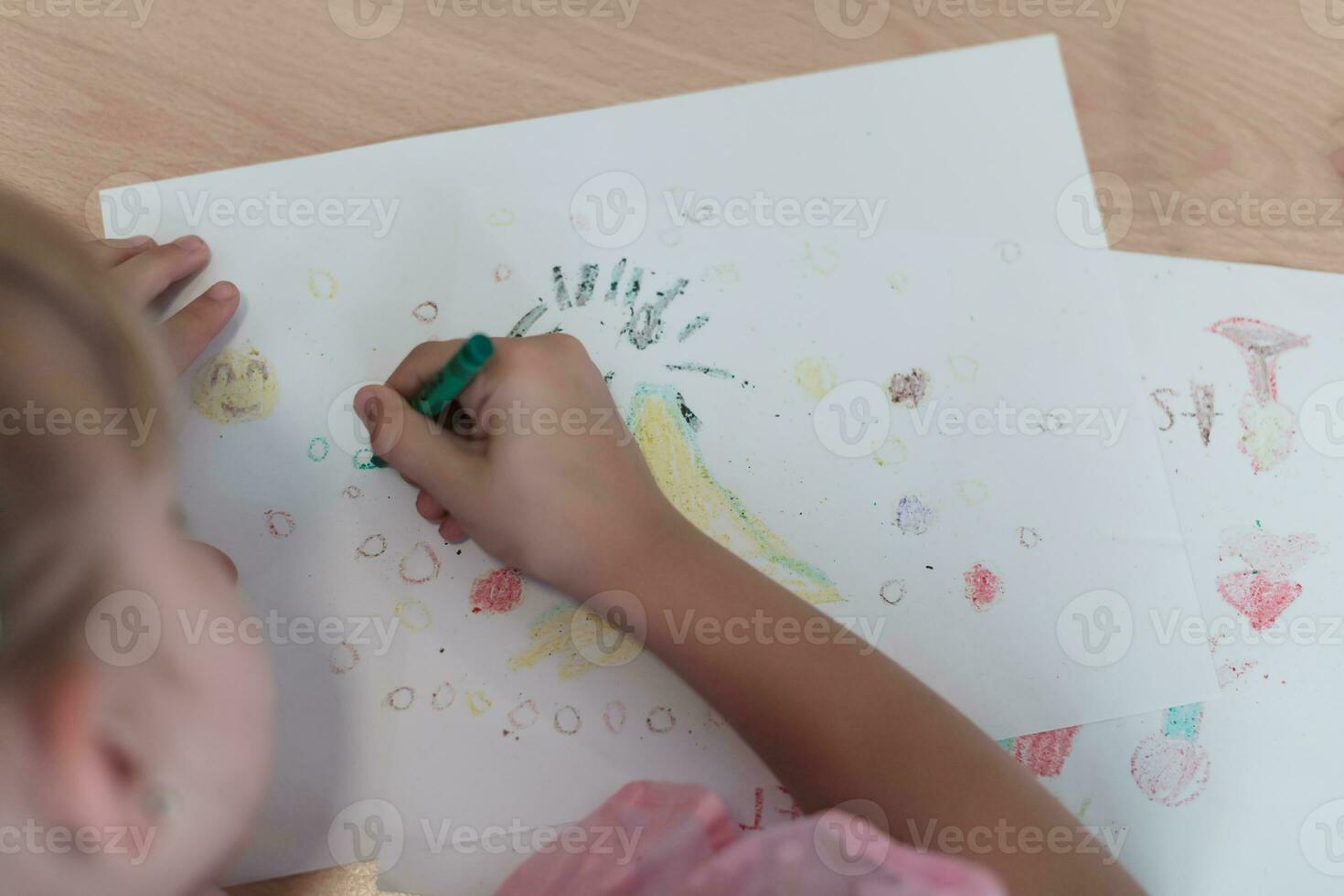 Little girls sitting in elementary school drawing on paper photo