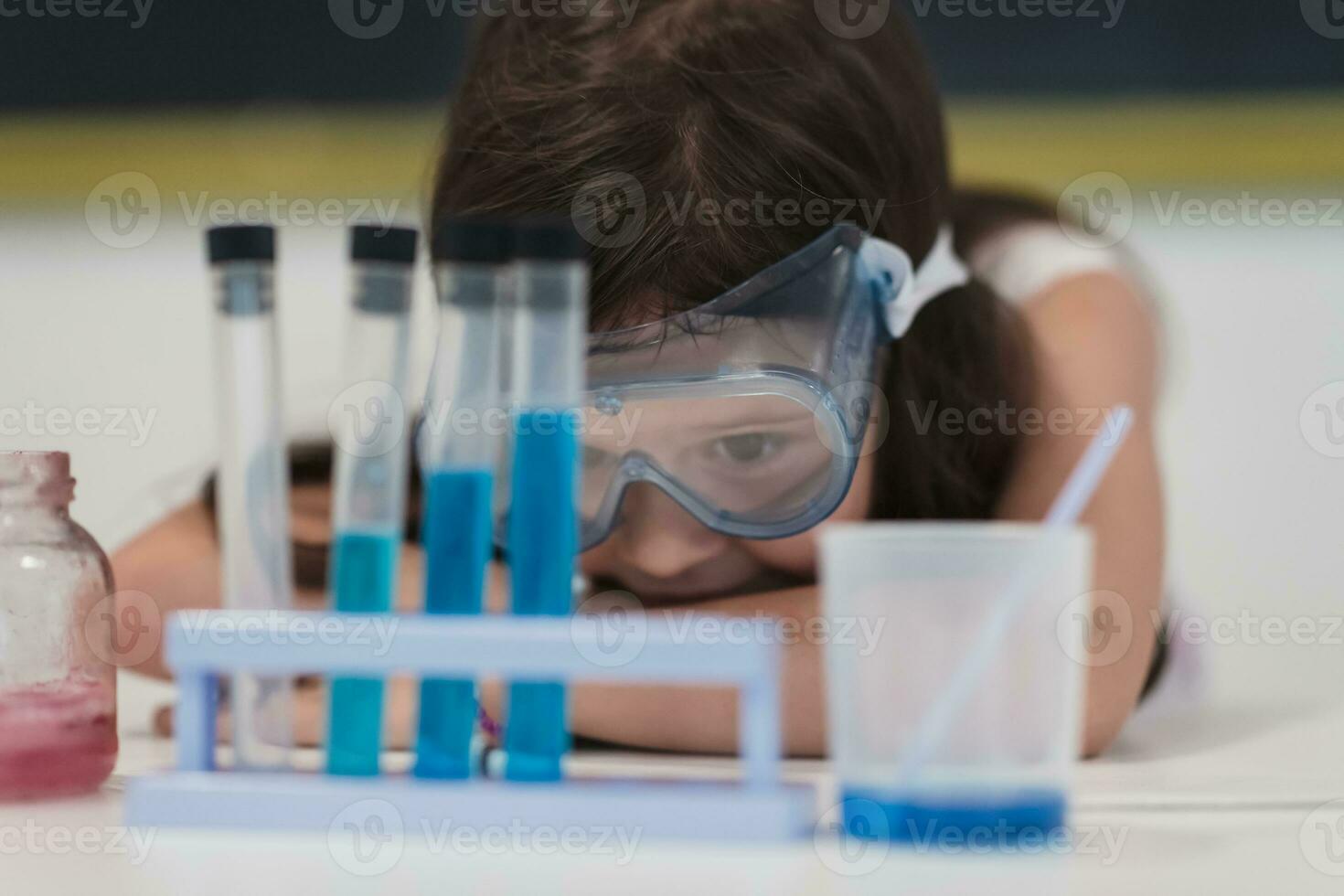 Elementary School Science Classroom Little girl Mixes Chemicals in Beakers. Children Learn with Interest photo