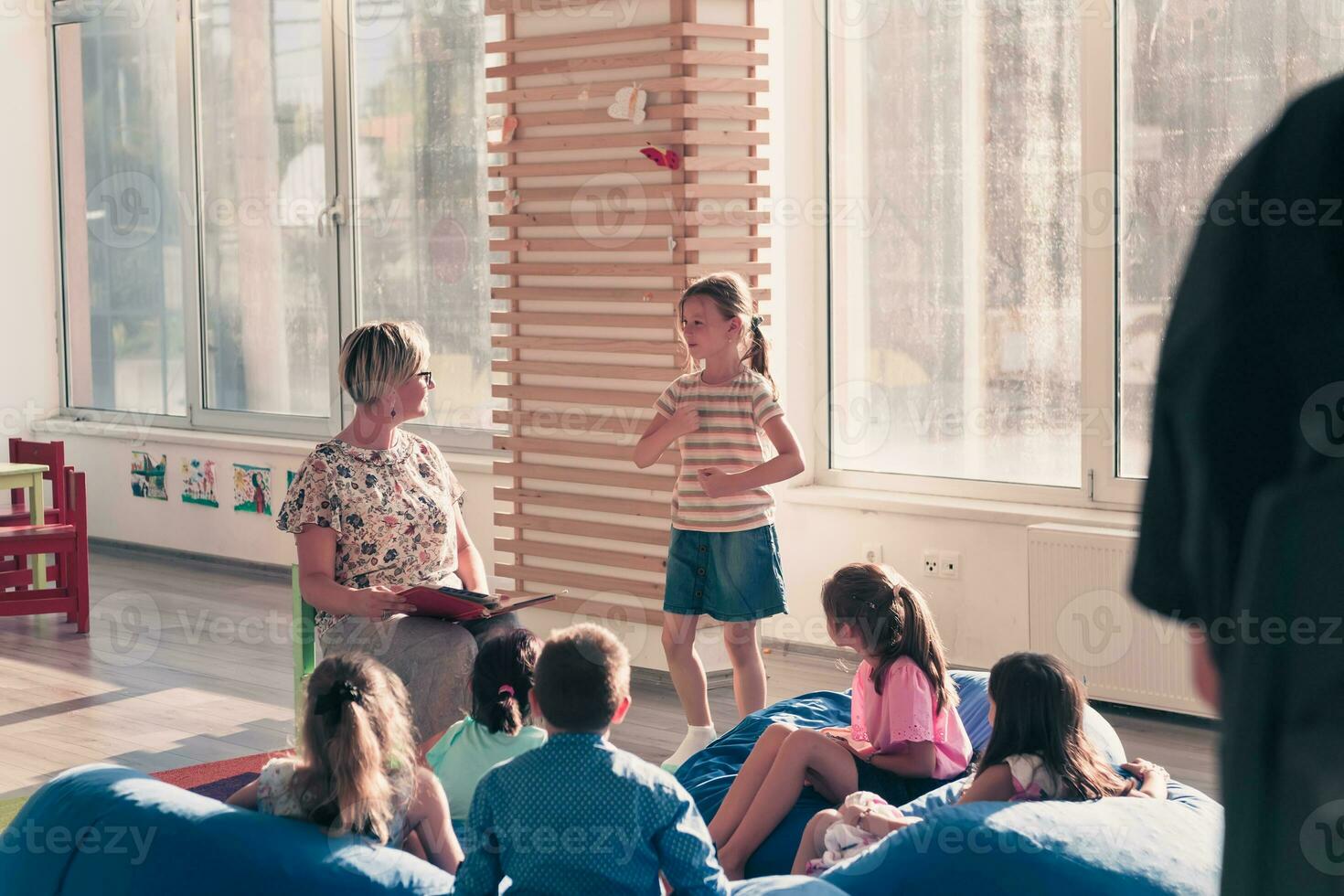 leyendo hora en elemental colegio o jardín de infancia, profesor leyendo un libro a niños en elemental colegio o jardín de infantes. selectivo atención foto