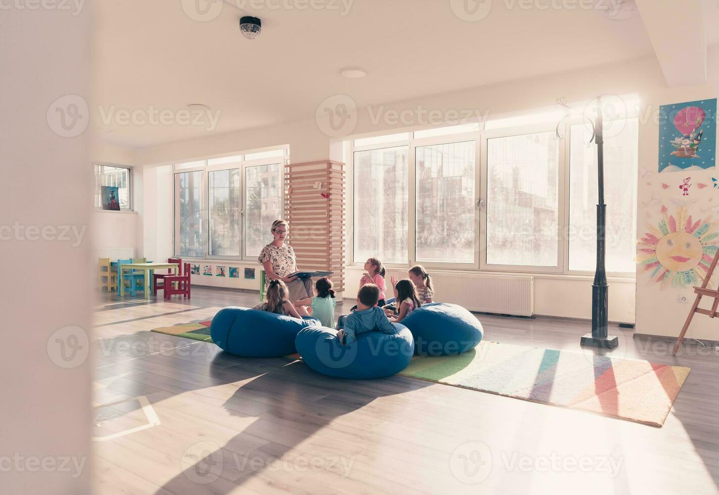 Reading time in elementary school or kindergarten, teacher reading a book to kids in elementary school or kindergaden. Selective focus photo