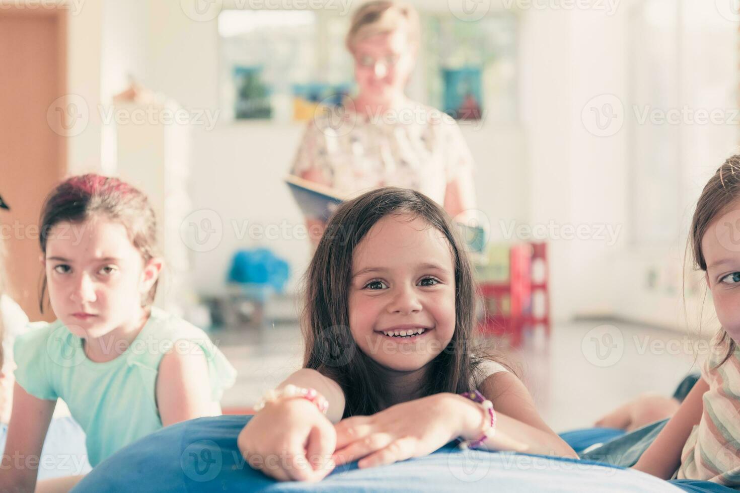 leyendo hora en elemental colegio o jardín de infancia, profesor leyendo un libro a niños en elemental colegio o jardín de infantes. selectivo atención foto