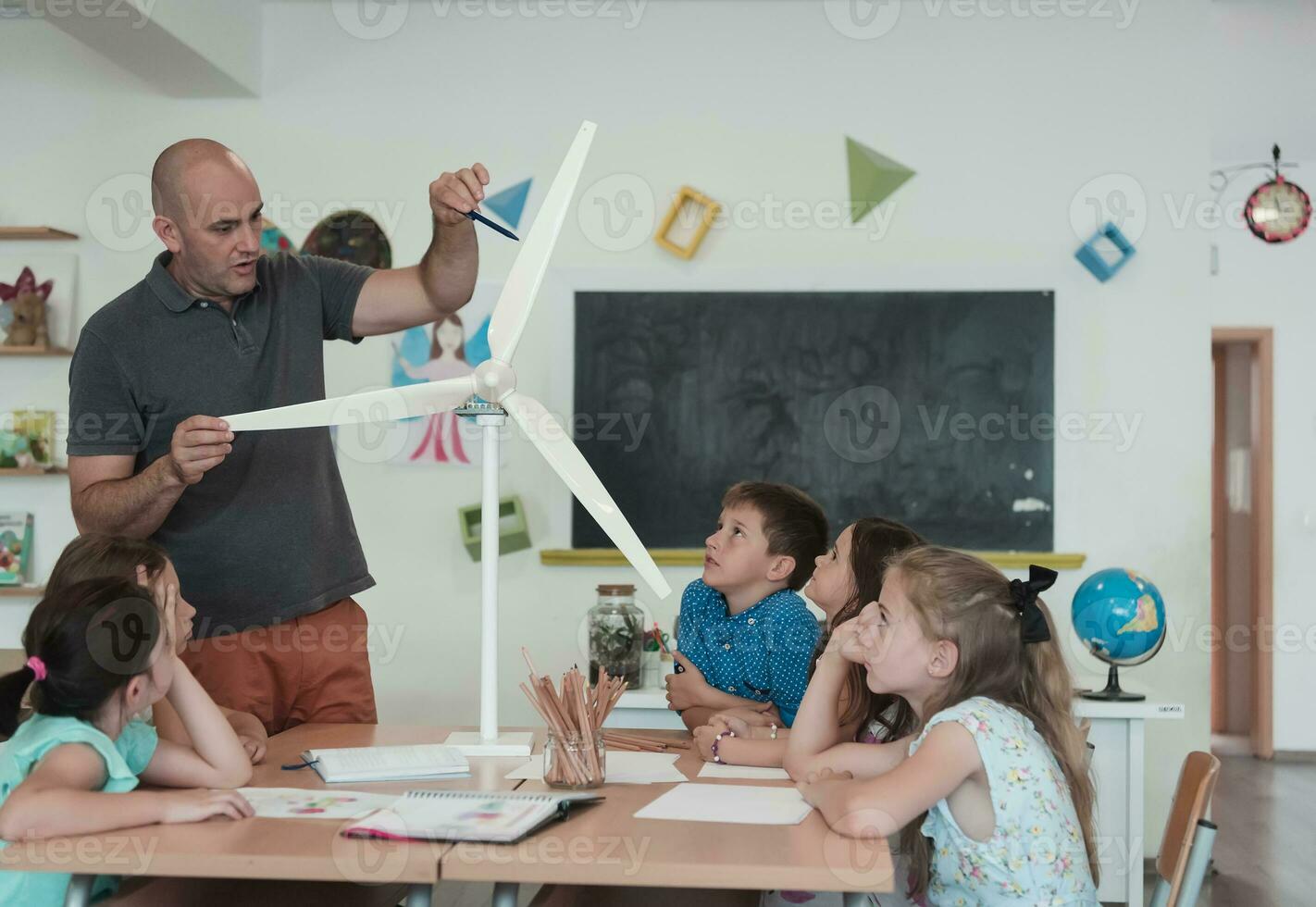 Elementary School Stem Robotics Classroom Diverse Group of Children Building and Programming windmill ecology robot concept. Together Talking and Working as a Team. Creative Robotics Engineering photo