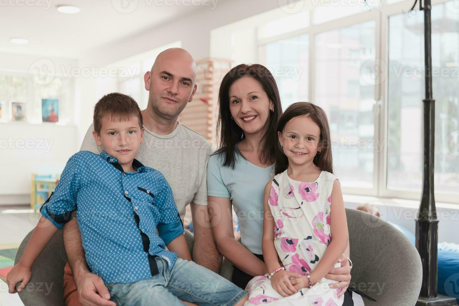 Portrait of a happy family. Photo of parents with children in a modern preschool classroom. Selective focus