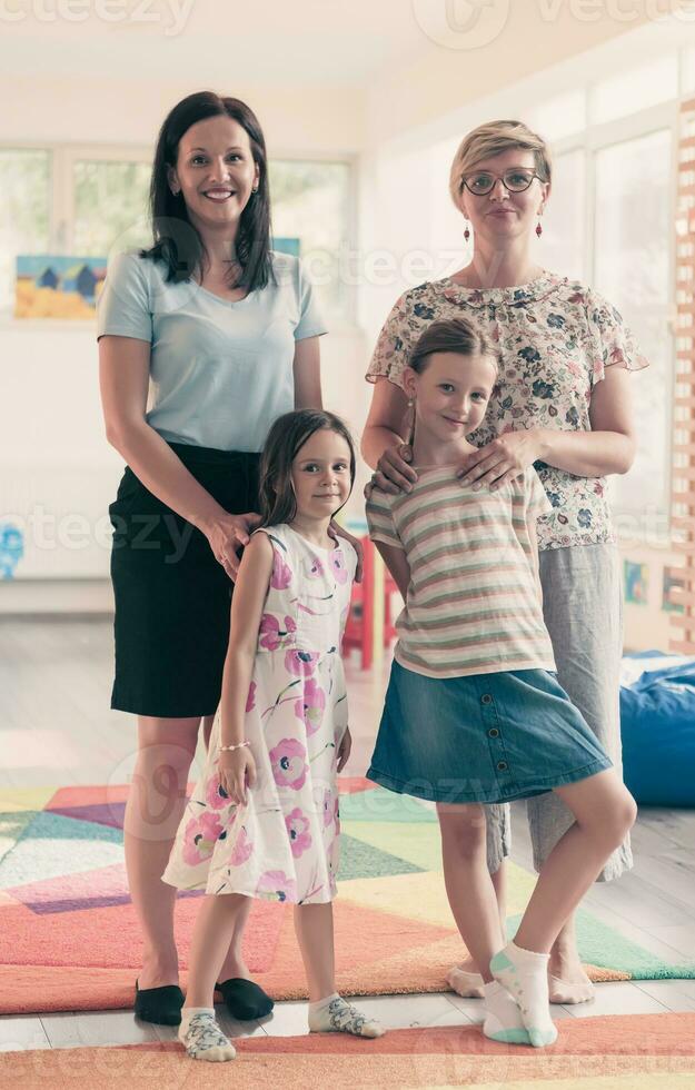 retrato de un madre con su hijas en un moderno preescolar institución. selectivo atención foto