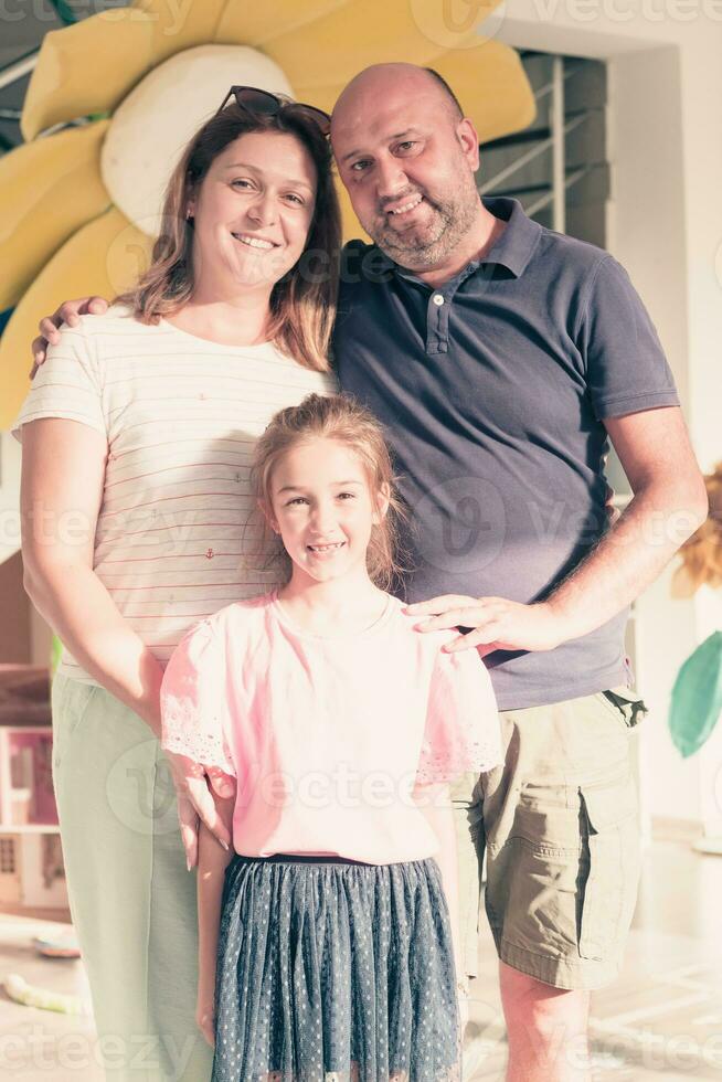 Portrait of a happy family. Photo of parents with children in a modern preschool classroom