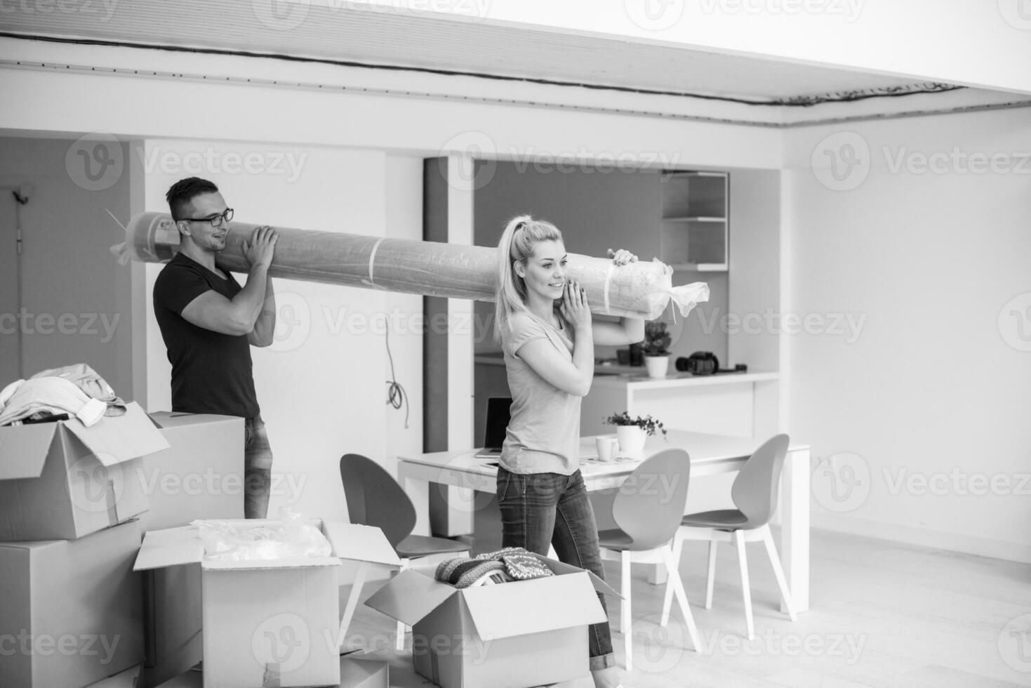 couple carrying a carpet moving in to new home photo