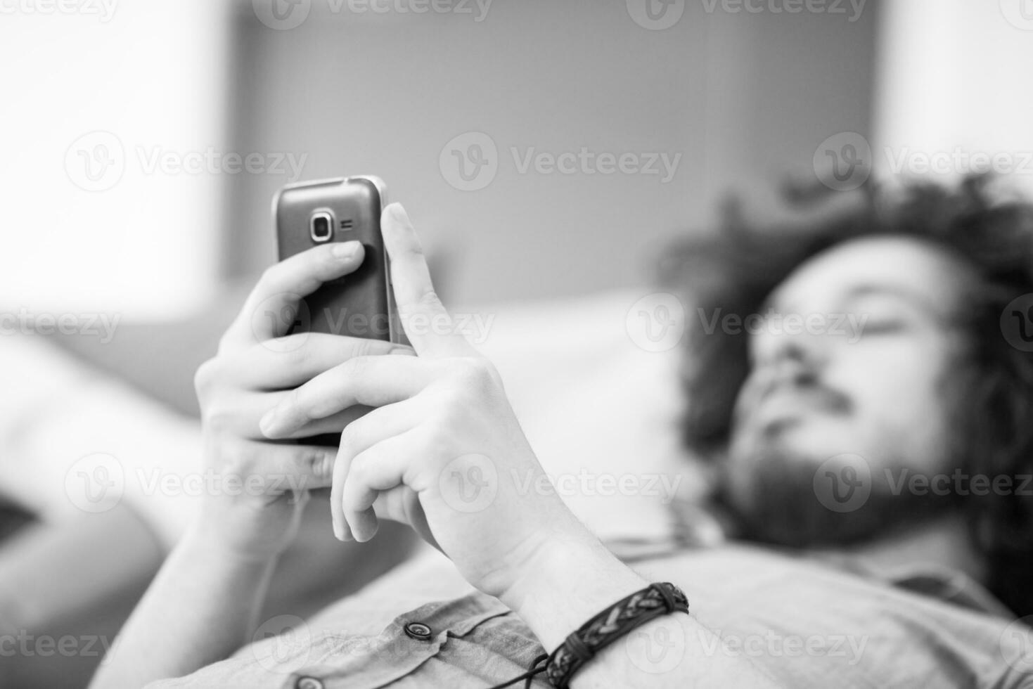 joven usando un teléfono móvil en casa foto