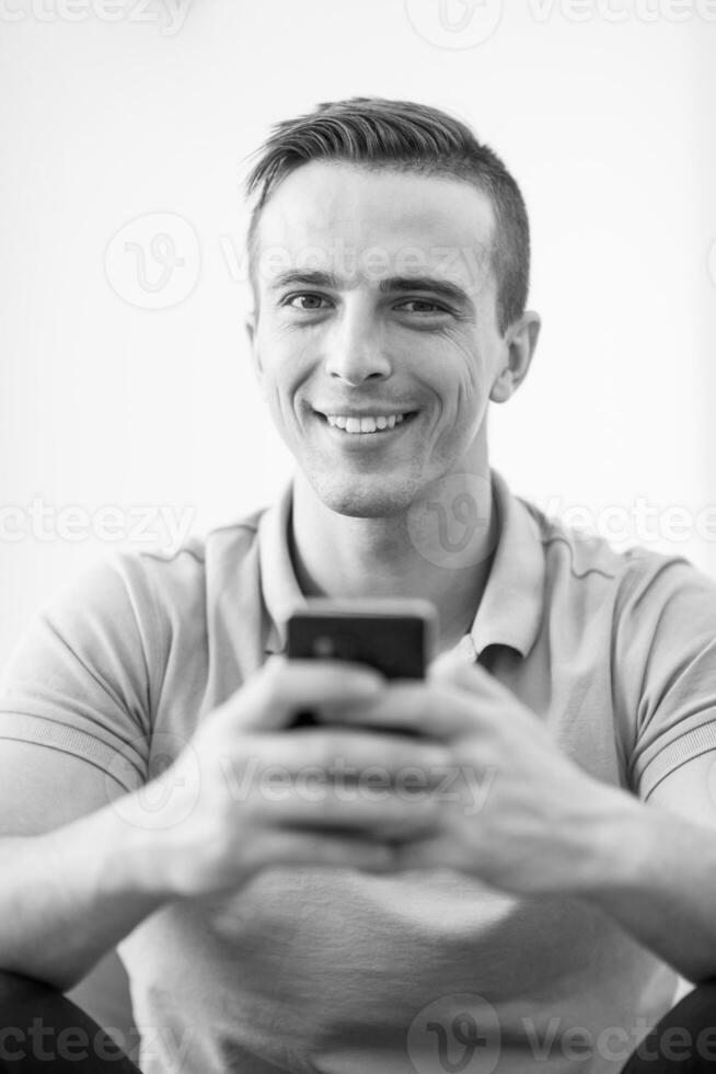 young man using a mobile phone  at home photo