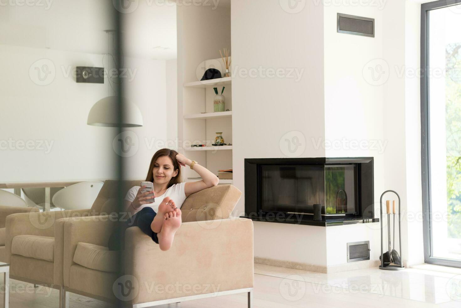 woman sitting on sofa with mobile phone photo