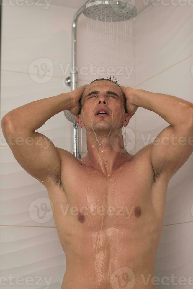 man taking shower in bath photo