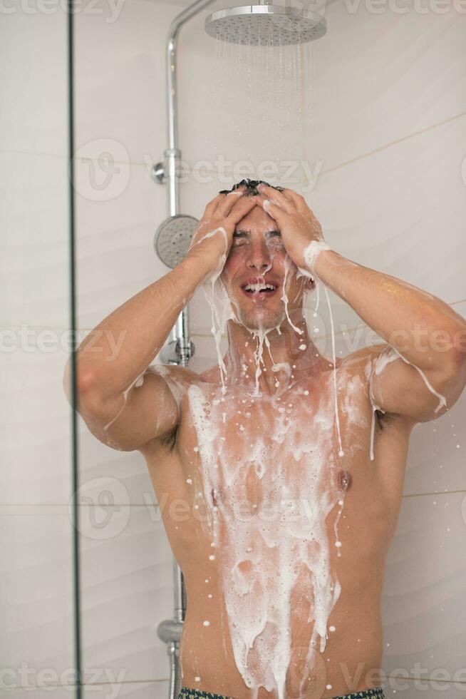 man taking shower in bath photo