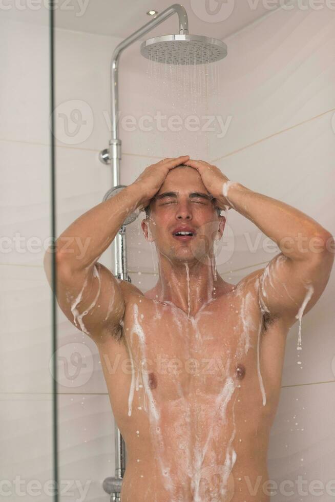 man taking shower in bath photo