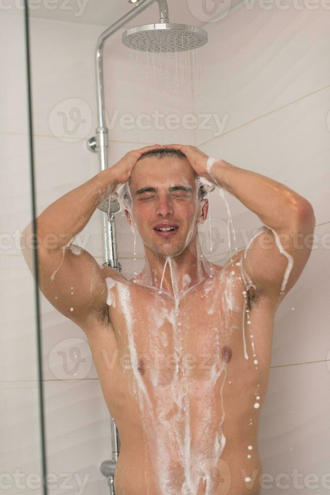 man taking shower in bath photo