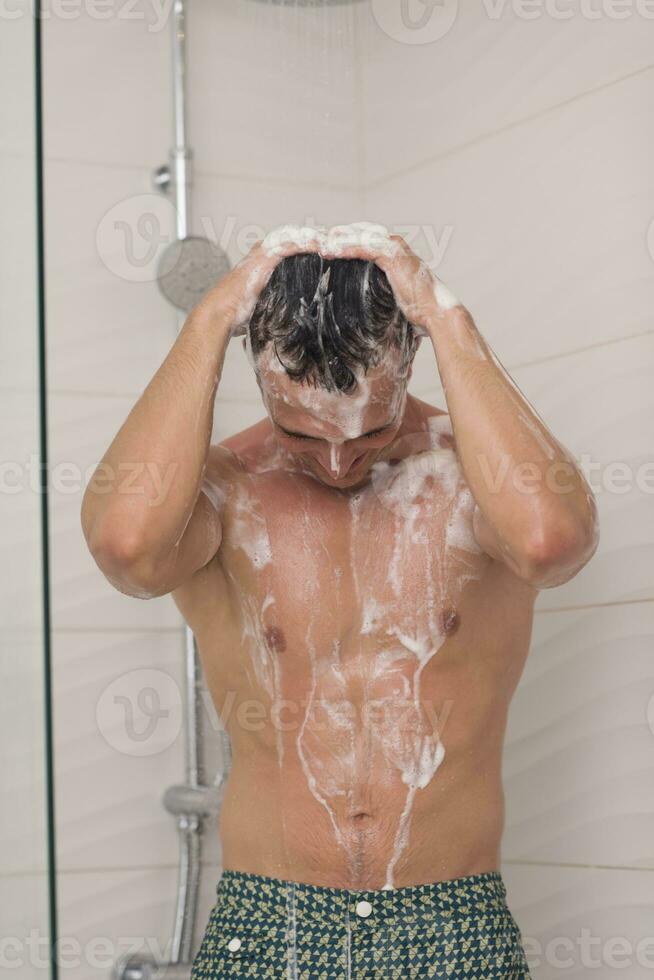 man taking shower in bath photo