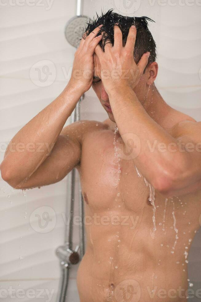 hombre duchándose en el baño foto