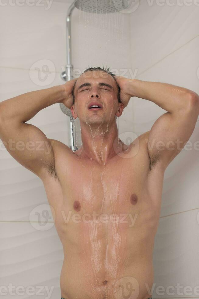 man taking shower in bath photo